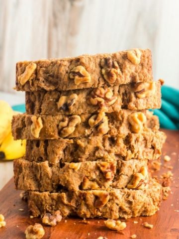 front view of a stack of 6 slices of banana bread with walnuts on the top