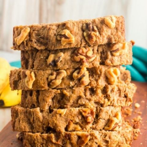front view of a stack of 6 slices of banana bread with walnuts on the top