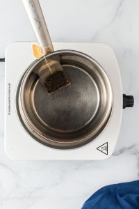 top view of a pan with water and tea bag seeping