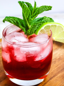 red pomegranate in a glass with a mint leaf