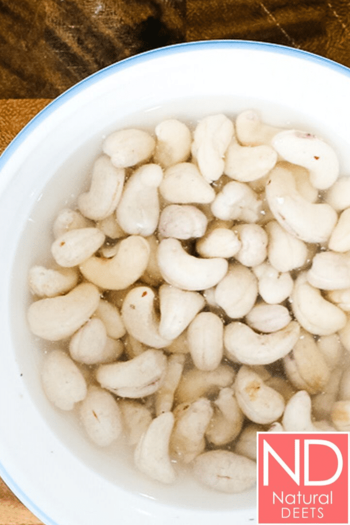 a bowl of raw cashews soaking in water