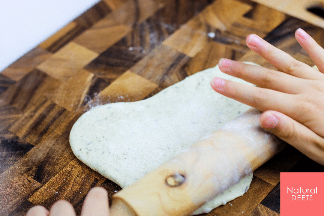 picture of kid hands rolling out pizza dough