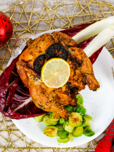 tip view of a roasted cornish game hen with a lemon slice on top