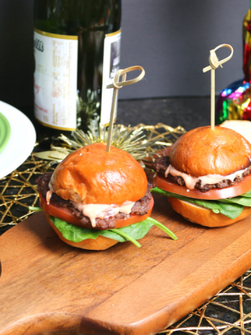 two sliders on a wooden cutting board