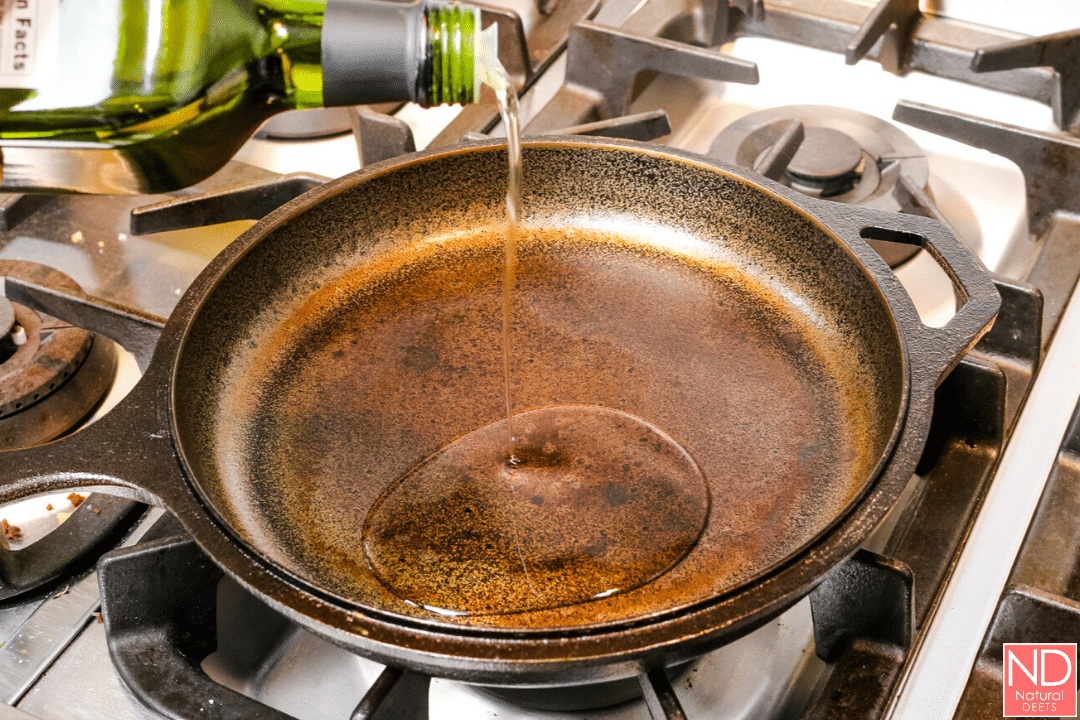 picture of cast iron skillet with oil being poured in