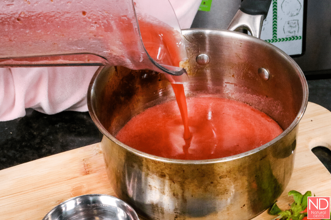 pouring blended fruit mixture into the pot 