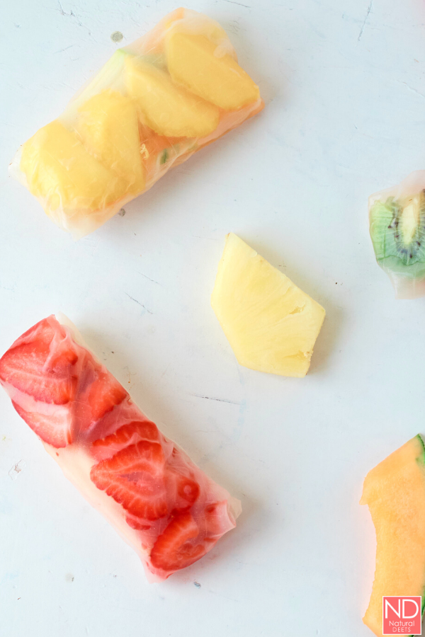 top down photo of the fruit rolls and a pineapple slice on a grey marble counter