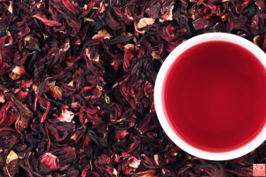 cup of hibiscus tea among hibiscus tea leaves