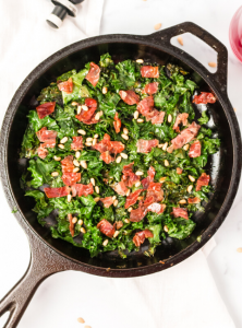top down view of the kale and prosciutto in a cast iron pan