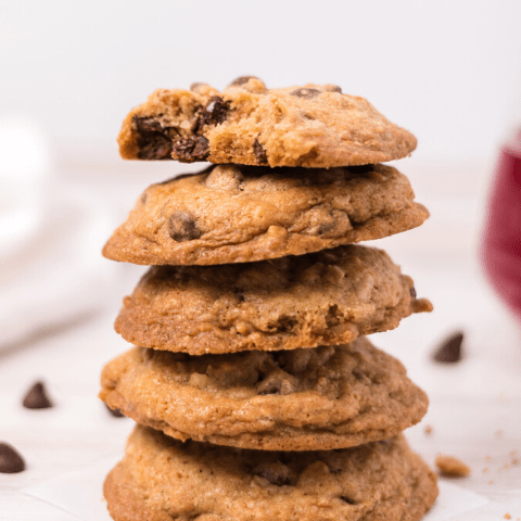a stack of 5 chocolate chip cookies and the top one has a bite