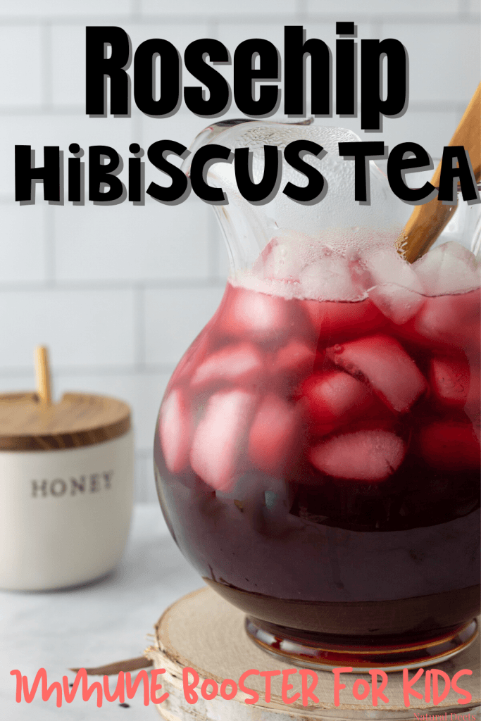 a pitcher of hibiscus tea with ice and a honey container in the background