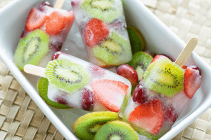 fruit and coconut popsicles in a bowl of ice