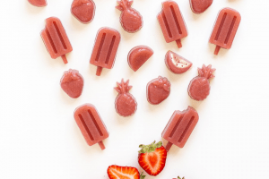 a top view of strawberries and popsicle shaped pink gummies
