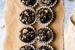 Top down view of chocolate balls in cupcake liners and sprinkled with chopped nuts