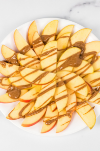 apples on a plate with almond butter drizzled