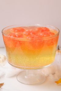a side view of the punch bowl with yellow juice on the bottom and bright orange ice on the top layer
