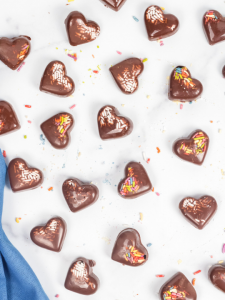 top view of chocolate hearts with sprinkles on a granite background
