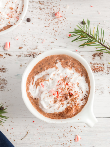 top view of peppermint hot chocolate in a white mug with whipped cream and crushed candy canes
