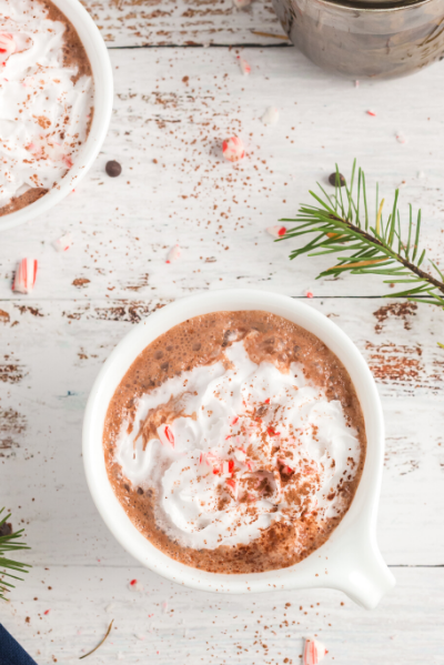 top view of a white mug with hot chocoalte and topped with whipped cream and crushed candy canes