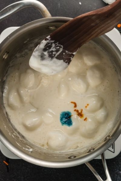 top view of a pot with melted marshmallows and food coloring - a drop of blue and a drop of yellow