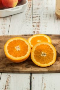 an orange cut in half and then a circular slice placed on top