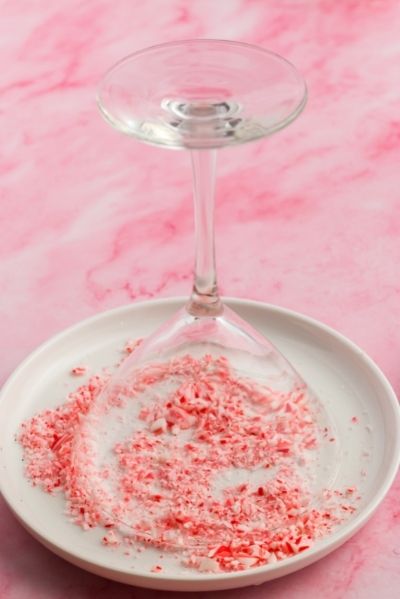 a martini glass upside down on a plate of crushed candy canes
