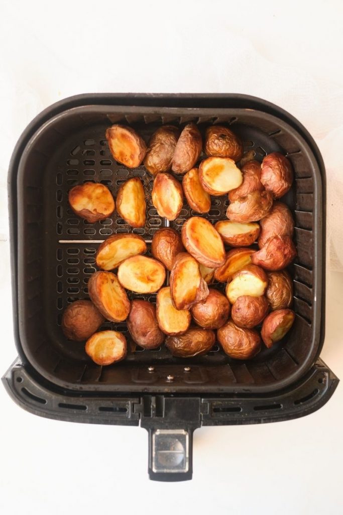 Top view of square air fryer pan with roasted potatoes in it