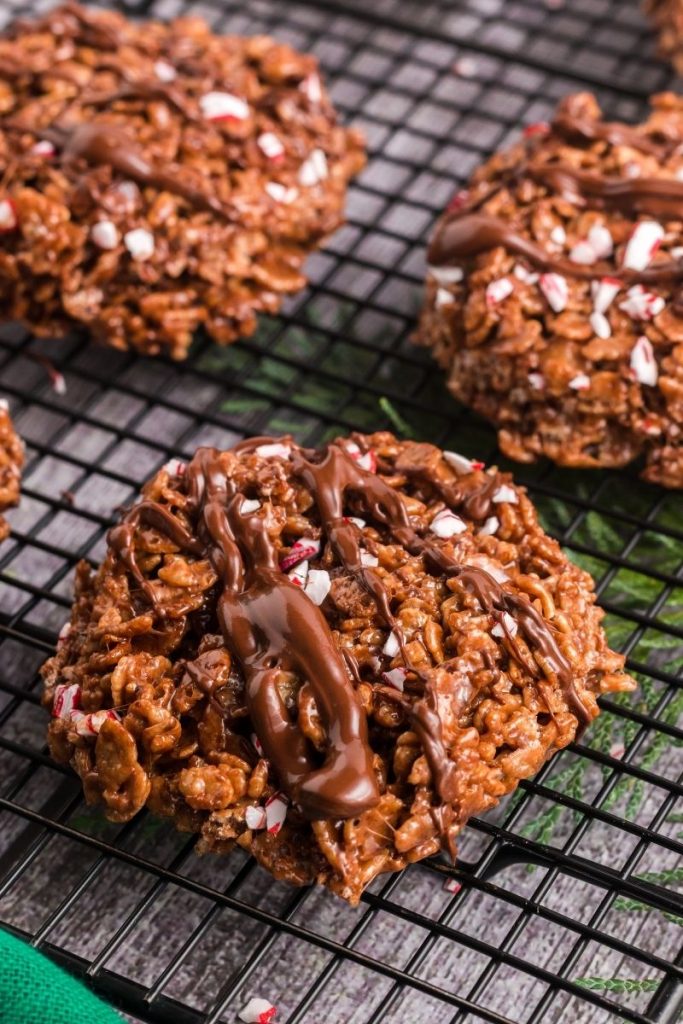 a round brown rice krispie treat with candy canes sprinkled and a chocolate drizzle