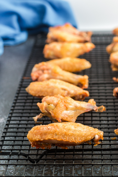 baked chicken wings on a black cooking rack