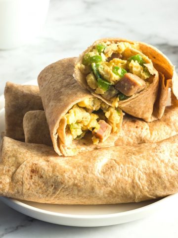 side view of burrito with scrambled eggs, sausage and green peppers