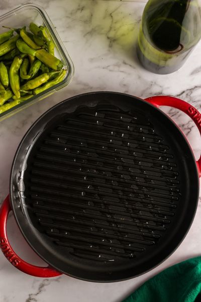 top view of a round black grill pan with oil on it