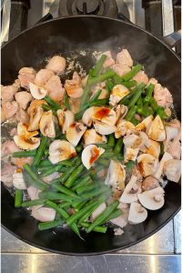 top view of chicken, green beans and mushrooms in a skillet