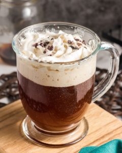 side view of a glass with coffee and whipped cream