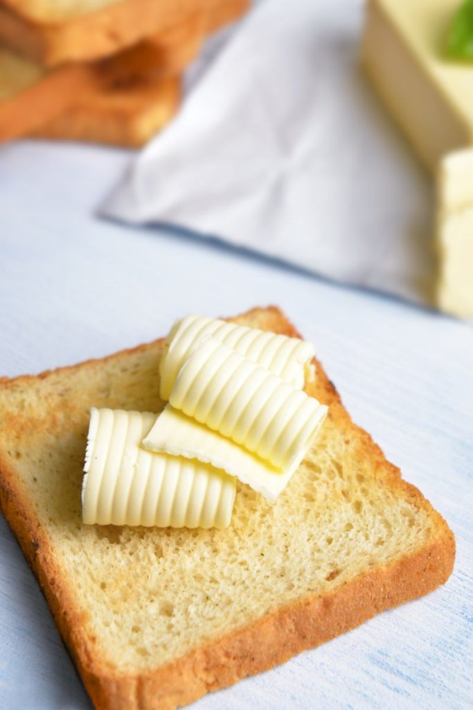 three squares of butter on a slice of toast