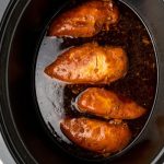 cooked chicken in a crockpot covered with soy sauce